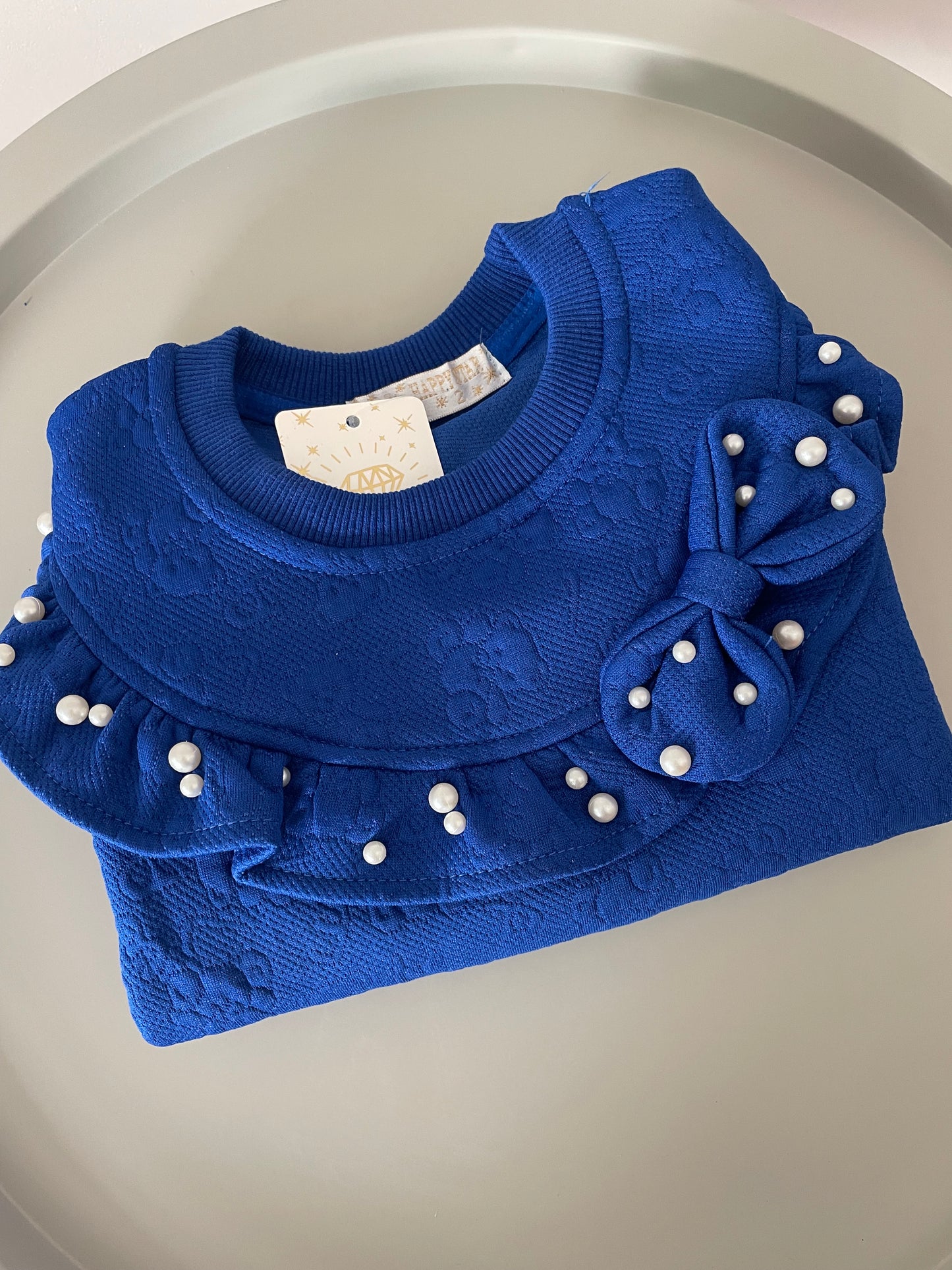 Pull bleu avec perle et noeud
