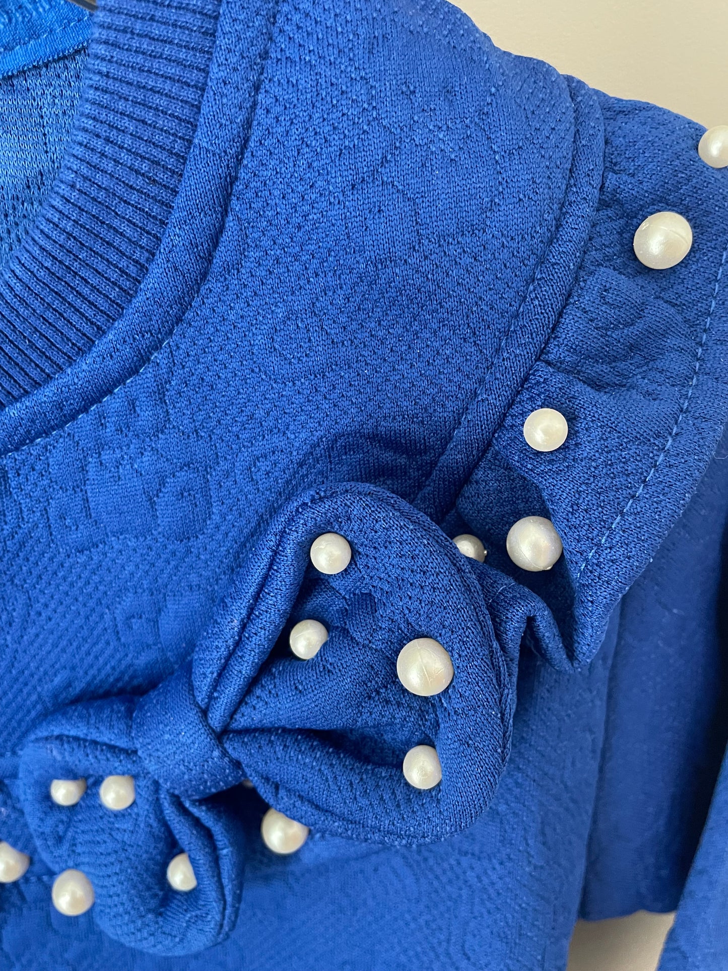 Pull bleu avec perle et noeud